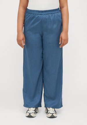 Blue wide-leg pants made of lightweight fabric, featuring an elastic waistband and a smooth texture. Paired with white and black sneakers.