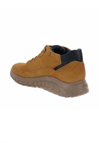 Brązowe zamszowe trampki z czarnymi akcentami, teksturowaną gumową podeszwą i sześciokątnym wzorem. Oferują sznurowany design oraz wyściełane wsparcie kostki.