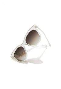 Ochelari de soare cu lentile degradee gri, în formă de ochi de pisică. Rama din plastic cu detalii subtile sclipitoare și tălpi netede, conice.