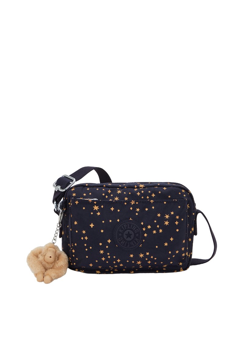 Navy fabric crossbody bag with gold star pattern, zip closure, adjustable strap, and a plush monkey keychain attached.