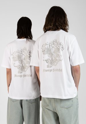 T-shirt bianca in cotone con una grande grafica argentata sulla schiena, che raffigura un'aquila e il testo "Sempre Fedele."