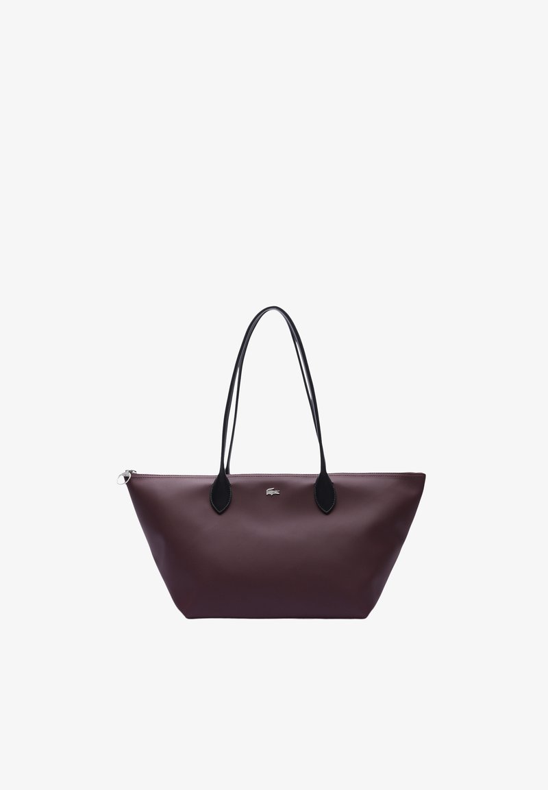 Sac fourre-tout bordeaux avec poignées noires, présentant une texture lisse et un détail logo subtil. Fermeture éclair et forme allongée.