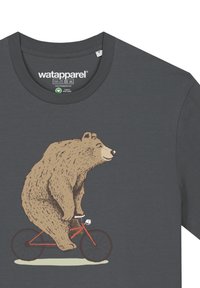 Graues T-Shirt mit einem cartoonhaften Bären, der ein rotes Fahrrad fährt. Der Bär ist kuschelig in einer hellbraunen Farbe, hat detaillierte Gesichtszüge und eine Glocke am Fahrrad.