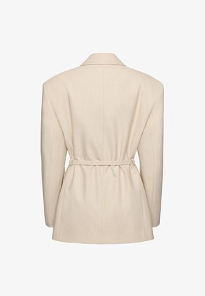 Krémovo sfarbené sako na mieru s výraznými ramenami a úzkym opaskom zdôrazňujúcim pás, zobrazené zozadu.