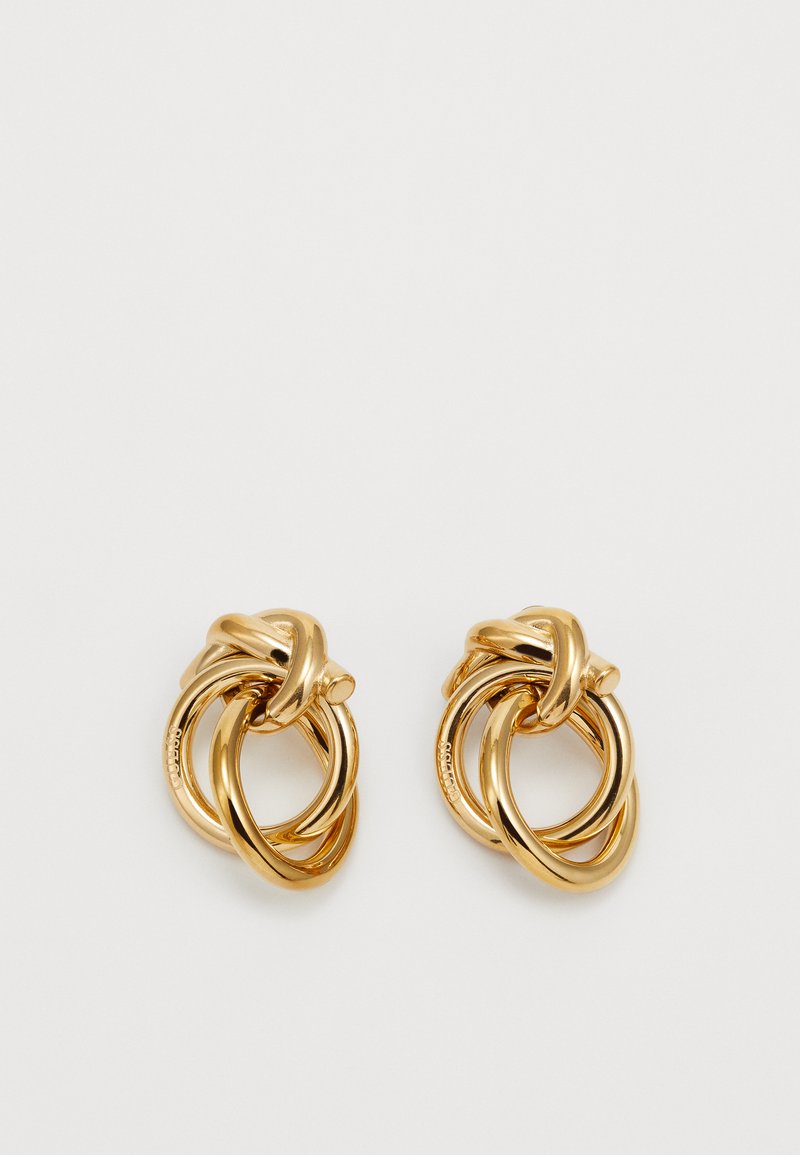 Brincos em metal dourado apresentando formas circulares entrelaçadas com um acabamento liso e polido. Cada brinco consiste em múltiplos anéis ligados.