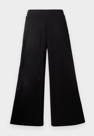 Črne široke hlače z elastiko v pasu, gladkim materialom in brez vidnih žepov ali zadrg, prikazane na belem ozadju.