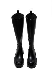 Bottes noires jusqu'aux genoux en cuir lisse avec une semelle épaisse et des languettes en haut pour un enfilage facile. Design robuste et minimal.