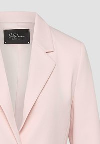 Blazer rose clair pour femme avec col à revers cranté et étiquette de marque noire "S. Oliver Black Label" à l'intérieur du col.