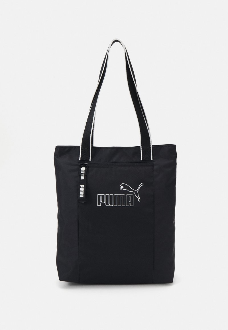 Sac fourre-tout noir Puma avec doubles bretelles, poche avant zippée et logo ainsi que texte Puma blancs sur le panneau avant.