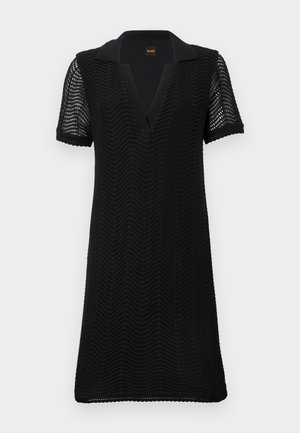 Robe noire à manches courtes avec motif en vagues texturé, col en V ouvert et tissu tricoté semi-transparent sur les manches et le corps.