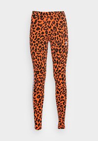 Leggings orange avec un motif léopard noir, dotés d'une taille haute et de rayures latérales. Fabriqués en tissu extensible pour plus de confort.