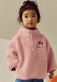 Rosa Fleece-Pullover mit hohem Kragen, ausgestattet mit drei Knöpfen und einer Minnie-Maus-Stickerei. Weicher Stoff und lockere Passform.