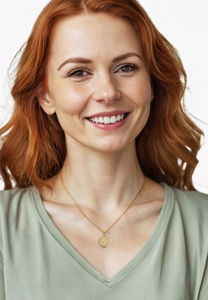 Goldkette mit einer strukturierten Herzanhänger, getragen mit einem hellgrünen Oberteil, das ein V-Ausschnitt-Design und einen glatten Stoff hat.