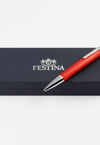 Red pen with a textured finish, chrome accents, and a pointed tip, positioned on a dark blue box featuring the "Festina" logo.
