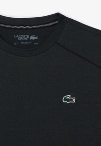T-shirt Lacoste Sport nera in vestibilità regolare, con un piccolo logo coccodrillo verde. Realizzata in tessuto morbido con scollo rotondo.