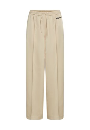 Pantalon beige à jambes larges avec ceinture élastique, cordon de serrage, plis sur le devant, et petit logo "Karl Lagerfeld Jeans" sur la hanche droite.