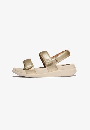 Gouden metalen sandalen met twee verstelbare velcro-straps, een gevoerd voetbed en een flexibele beige zool. Gladde textuur met een minimalistisch ontwerp.