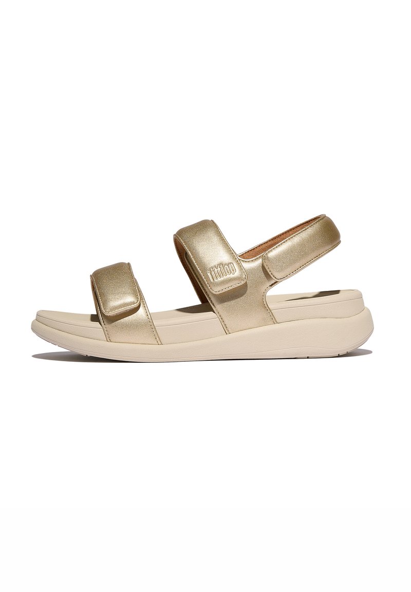 Gouden metalen sandalen met twee verstelbare velcro-straps, een gevoerd voetbed en een flexibele beige zool. Gladde textuur met een minimalistisch ontwerp.