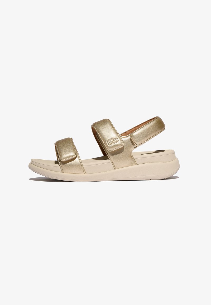 Gouden metalen sandalen met twee verstelbare velcro-straps, een gevoerd voetbed en een flexibele beige zool. Gladde textuur met een minimalistisch ontwerp.