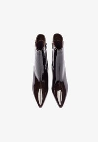 Juodos lakuotos odinės aulinės botai su smailiomis nosimis, šoninėmis užtrauktukais ir lygia, blizgia apdaila. Pasižymi elegantiška siluetu ir minimaliais siūlais.