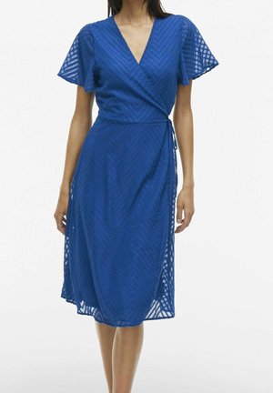 Niebieska sukienka kopertowa z krótkimi, rozkloszowanymi rękawami, wzorem jodełki i długością do połowy łydki. Posiada wiązanie w talii.