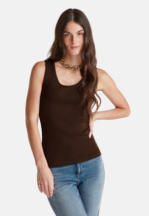 Bruine tanktop met een ronde hals, gemaakt van soepel materiaal. Gecombineerd met lichtblauwe jeans en een chunky gouden ketting.