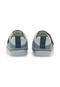 Zapatos infantiles en azul y gris claro con un acabado de cuero suave, correas elásticas y tiradores traseros para ponérselos fácilmente. Suela de goma.