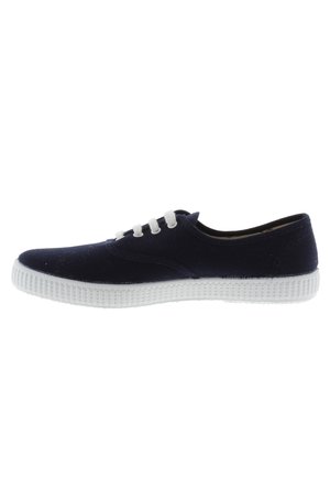 Navy canvas sneaker with white rubber sole, featuring five white eyelets and a stitched design along the side for added detail.