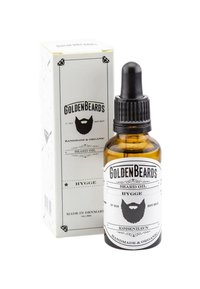 Amberfärgad glasflaska med en svart droppare, märkt "Golden Beards Hygge Beard Oil," förpackad i en vit pappbox med svarta accenter.