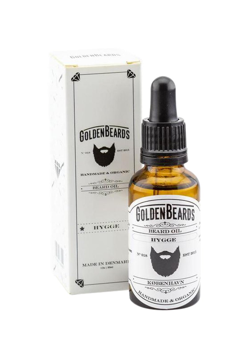 Amberfärgad glasflaska med en svart droppare, märkt "Golden Beards Hygge Beard Oil," förpackad i en vit pappbox med svarta accenter.