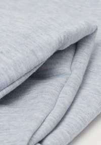 Lichtblauwe katoenen stof met een gladde textuur, die een gevouwen ontwerp laat zien. De stof heeft een subtiel, uniform patroon.
