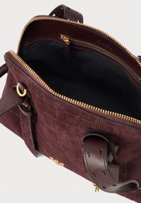 Tmavoburgundová textúrovaná kožená kabelka so zlatým zipsom, dvomi koženými držadlami a čiernou vnútornou podšívkou, zobrazená otvorená zhora.