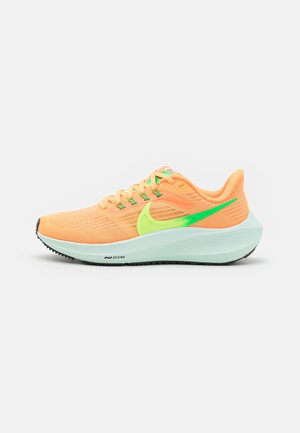 Zapatilla de running Nike naranja y verde con suela azul clara, parte superior de malla y detalle de amortiguación "Air Zoom" en el lateral.