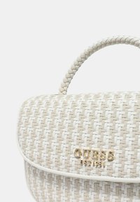 Borsa a tracolla intrecciata crema e bianca con pattina curvata, dettaglio del logo dorato e manico testurizzato. Fodera liscia e forma strutturata.