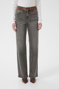 Hallid laia säärega teksad, mis on valmistatud teksariidest. Neil on kõrge värvl, viis taskut ja pruun seemisnahast vöö. Kandmise ajal pruunide teravate varbaga kontsakingadega.