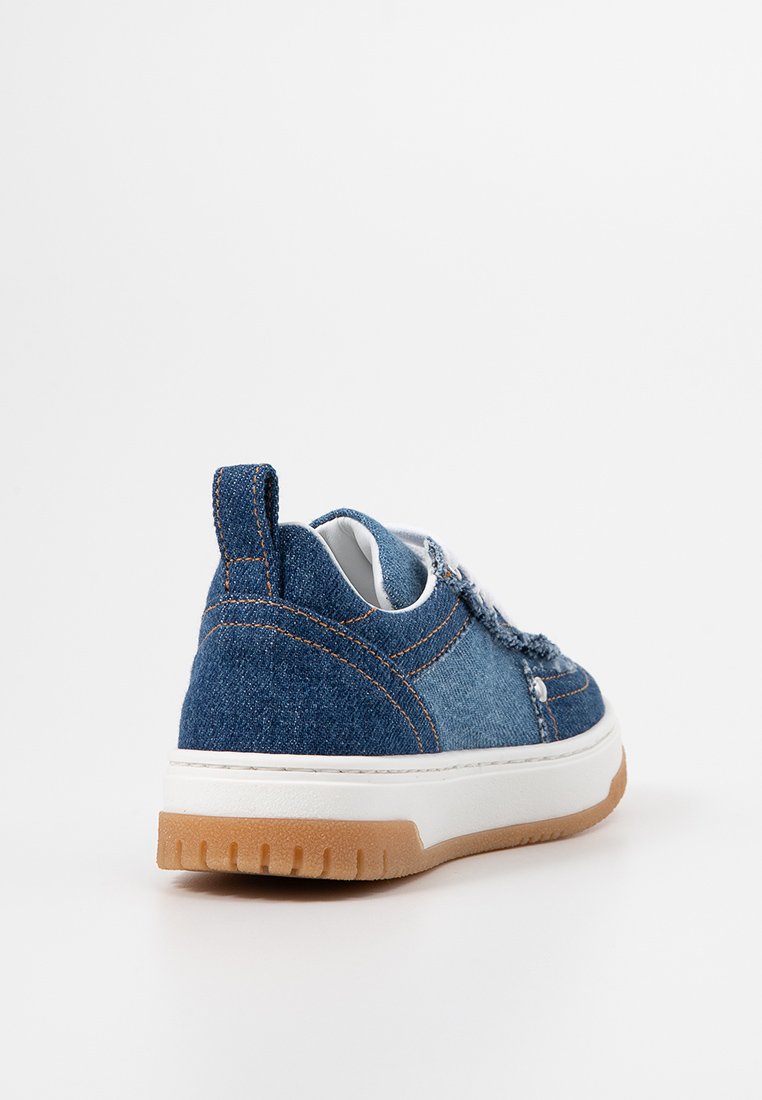 Sneaker in denim con tomaia blu con cuciture visibili, suola in gomma bianca e fondo beige. Tallone rinforzato per facilitare l'indossamento.