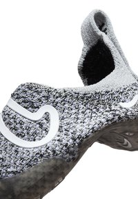 Zapato de punto sin cordones; mezcla de color gris y negro; parte superior elástica; diseño texturizado; detalle del logo blanco en el lado; suela negra.