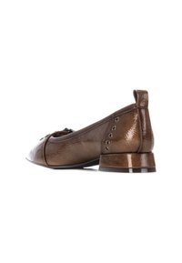 Zapato de charol marrón con punta redondeada, acabado texturizado, tacón pequeño y ojales decorativos a lo largo del costado.