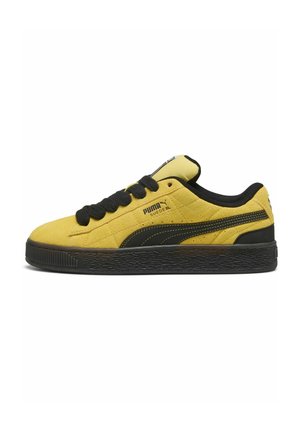 Gul Puma Suede XL sneaker med sort sål, sorte snørebånd og Puma-logo på siden og tungen, set fra ydersiden.