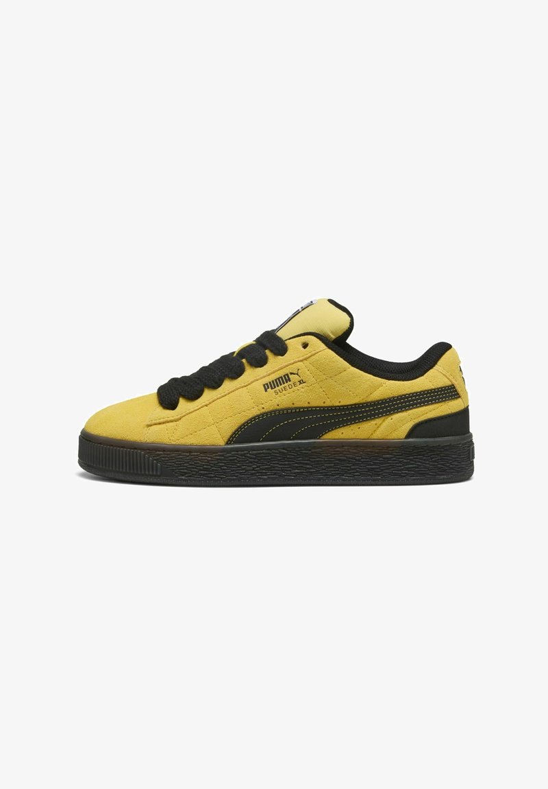 Sneaker Puma Suede XL jaune avec semelle noire, lacets noirs et logo Puma sur le côté et la languette, vue de l'extérieur.