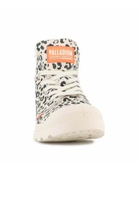 Zapatillas altas de caña con lona beige y estampado de leopardo negro, cordones blancos, etiqueta naranja y suela de goma texturizada.