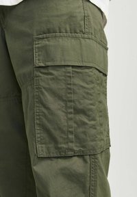 Pantaloni cargo de culoare verde măsliniu, fabricați dintr-un material durabil, dotati cu buzunare laterale mari, detalii cusute și un croi lejer.