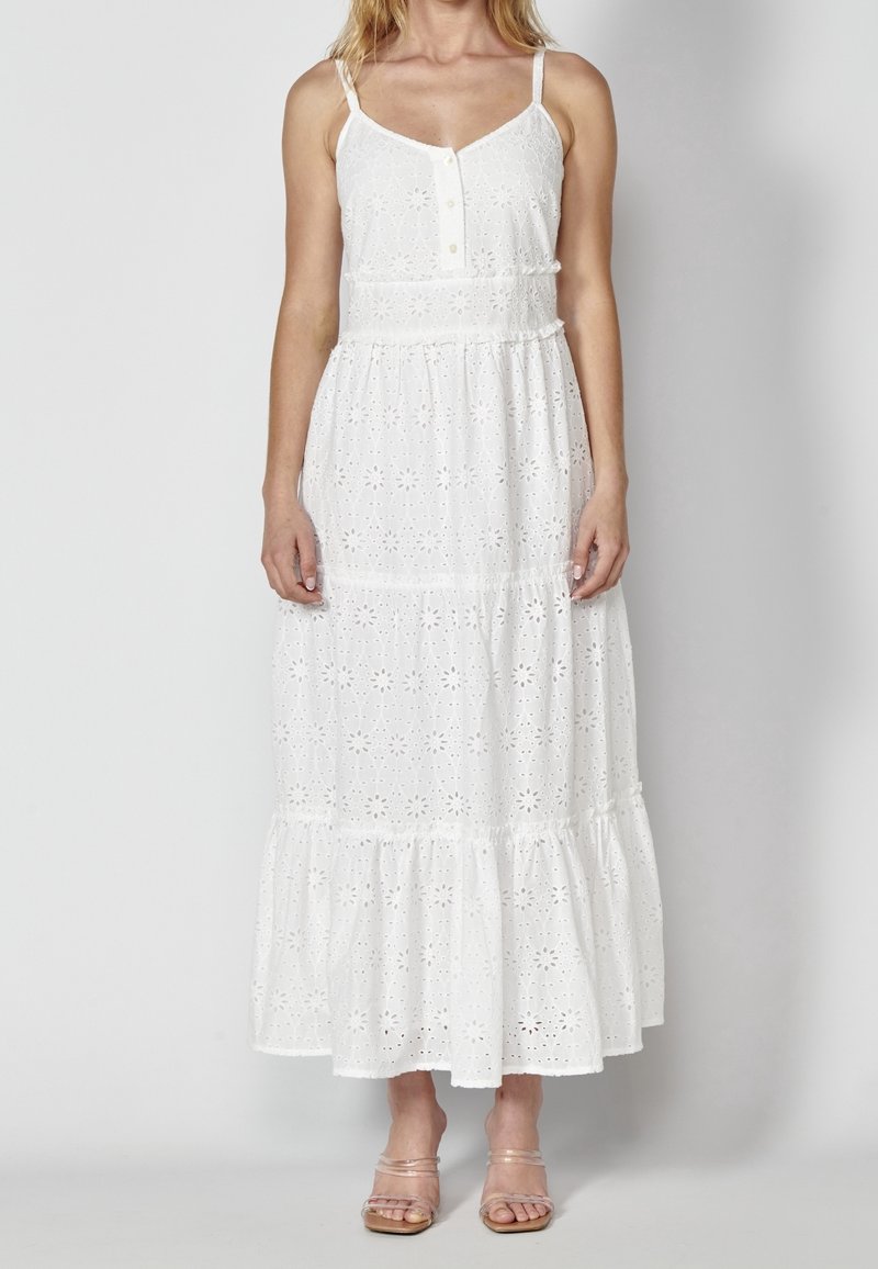 Vit maxiklänning med blommigt ögonlappsmönster, tunna axelband, knäppning framtill, lager-på-lager volangkant och lätt bomullstyg.