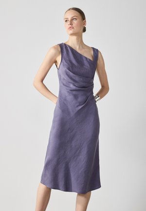 A sleeveless, knee-length dress in a soft, textured lavender fabric features a draped front and an asymmetric neckline.