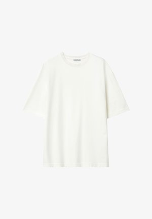 T-shirt blanc uni à manches courtes, coupe ample, avec col rond et étiquette de col visible, présenté sur un fond blanc.