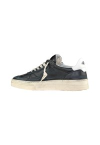 Sneaker in pelle nera con accenti bianchi, punta arrotondata e suola in gomma beige. Presenta lacci crema e un dettaglio testurizzato sul tallone.