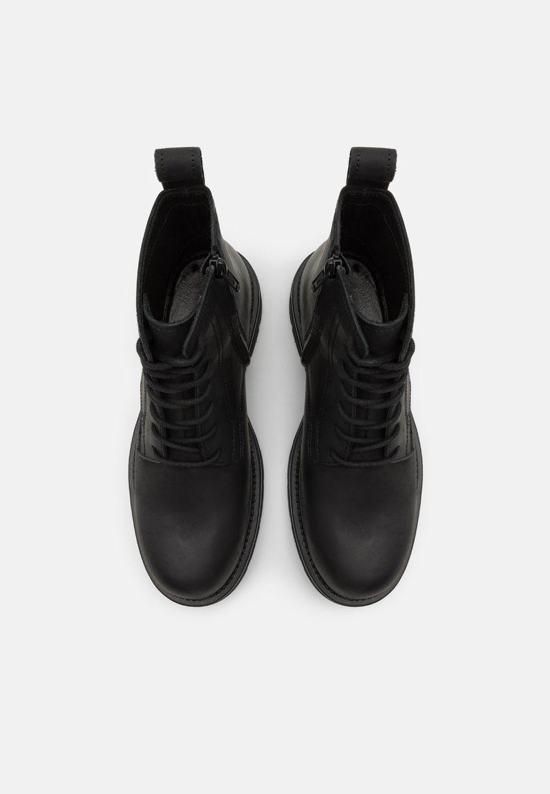 Schwarze Lederstiefeletten mit runder Spitze, Schnürung vorne und seitlichen Reißverschlüssen. Mit einem Zugschlaufe an der Rückseite für ein einfaches Anziehen.