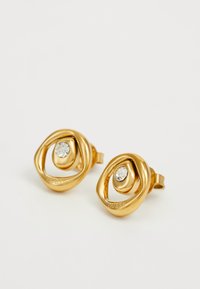 Boucles d'oreilles en métal doré avec un design torsadé, ornées d'un rhinestone transparent au centre. Texture lisse avec une finition polie.