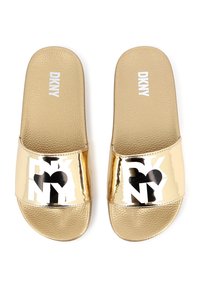 Gouden schuiflopen met een gestructureerde binnenzool. Voorzien van een glanzende, reflecterende band met een zwart "DKNY" logo op een witte achtergrond.