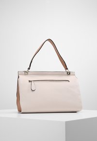 Sac à main en cuir rose clair avec une forme structurée, doté d'une anse supérieure, d'une poche zippée à l'extérieur et d'accompagnements bruns contrastants.